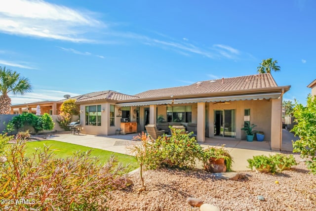 back of house with a patio area, a tile roof, and stucco siding