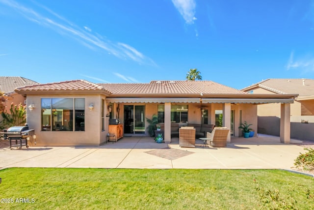 back of house featuring a patio area, a tile roof, a yard, and stucco siding