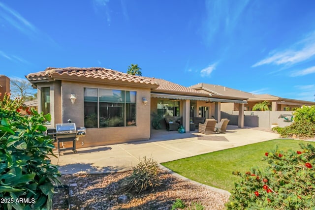 rear view of house featuring stucco siding, a lawn, a patio area, fence, and a tiled roof