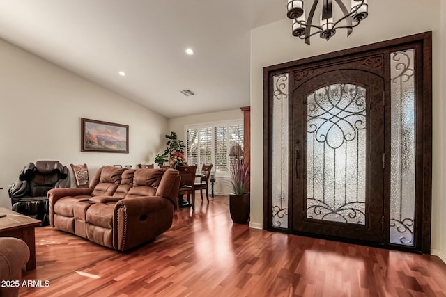 foyer entrance with recessed lighting, a notable chandelier, wood finished floors, visible vents, and vaulted ceiling