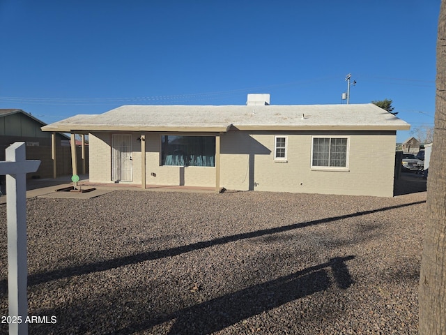 back of house featuring brick siding and a patio area