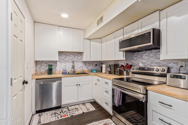 kitchen featuring tasteful backsplash, visible vents, wooden counters, appliances with stainless steel finishes, and a sink