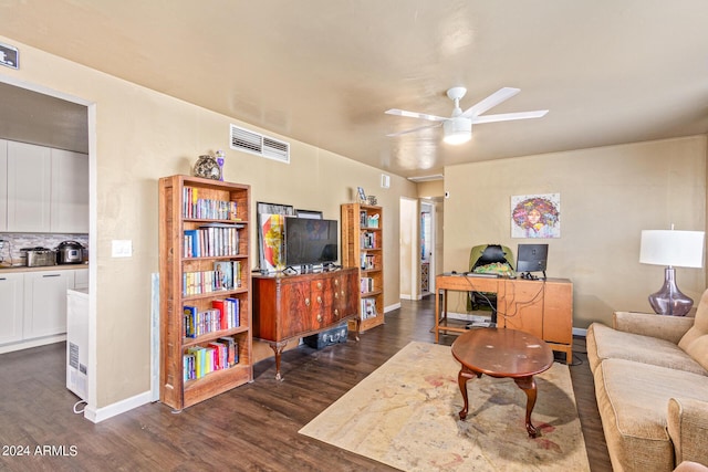 living area with visible vents, baseboards, dark wood finished floors, and a ceiling fan