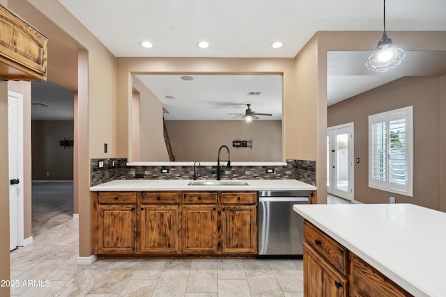 kitchen featuring a sink, brown cabinets, light countertops, and stainless steel dishwasher