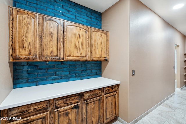 kitchen featuring tasteful backsplash, light countertops, and baseboards