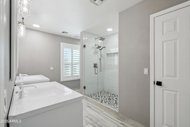 bathroom featuring a sink, visible vents, and a shower stall