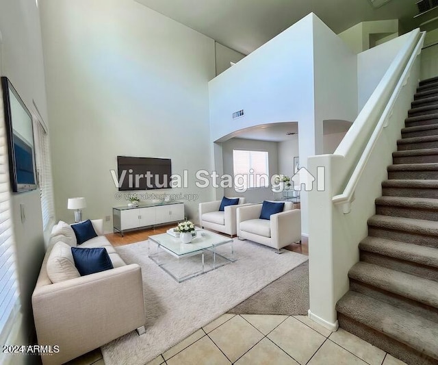 living room featuring a towering ceiling and light tile patterned flooring