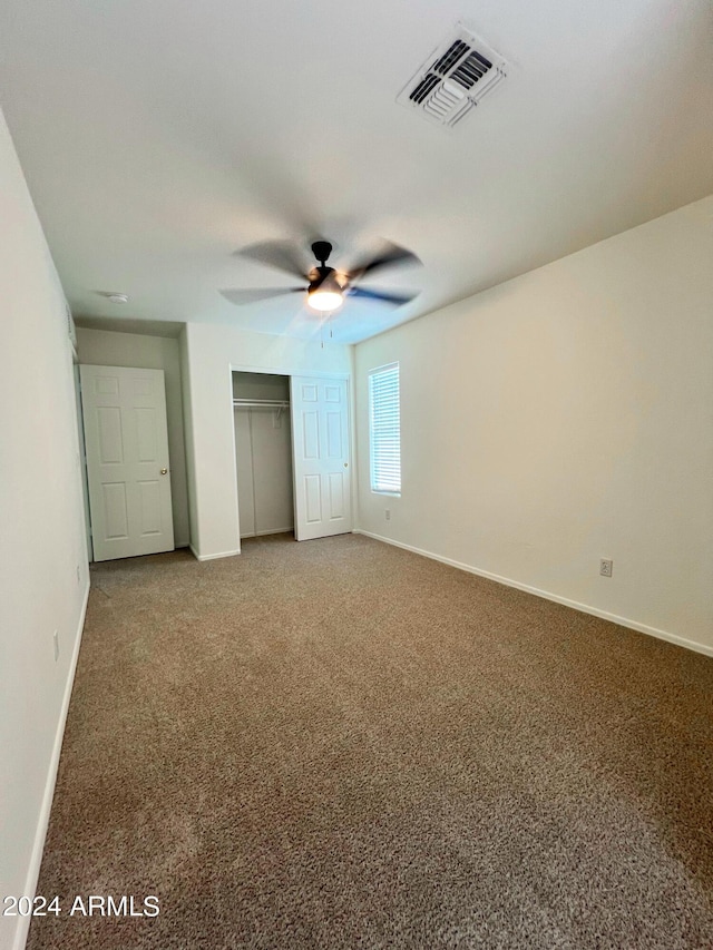 unfurnished bedroom with carpet floors, a closet, and ceiling fan