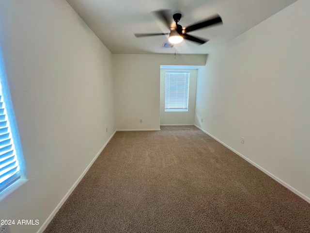 empty room featuring ceiling fan and light carpet