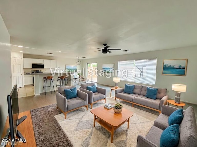 living room with light hardwood / wood-style floors and ceiling fan