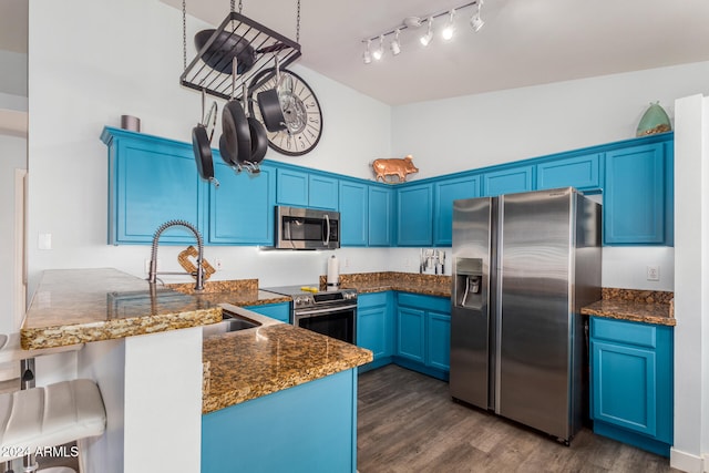 kitchen with kitchen peninsula, dark hardwood / wood-style flooring, stainless steel appliances, blue cabinets, and a high ceiling