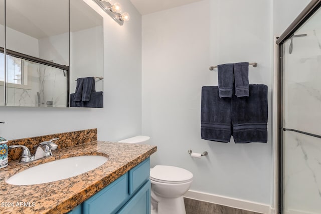 bathroom with vanity, toilet, wood-type flooring, and walk in shower