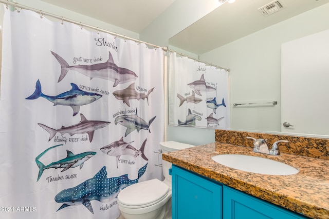 bathroom with vanity, a shower with shower curtain, and toilet