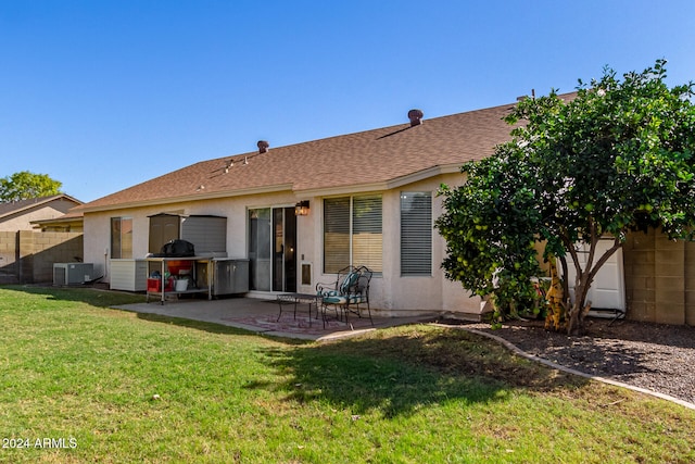 back of property with a lawn, a patio area, and central AC