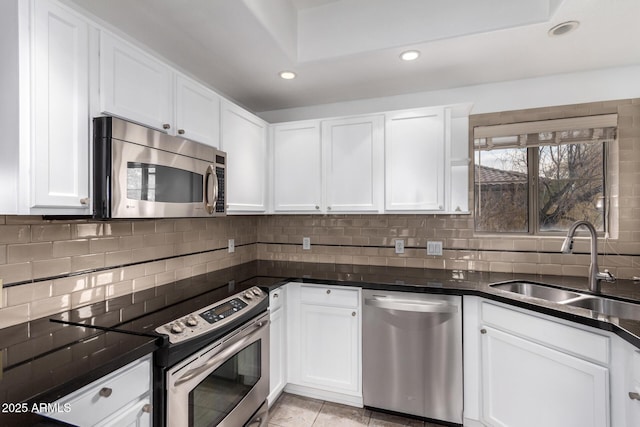 kitchen with white cabinetry, stainless steel appliances, sink, and decorative backsplash