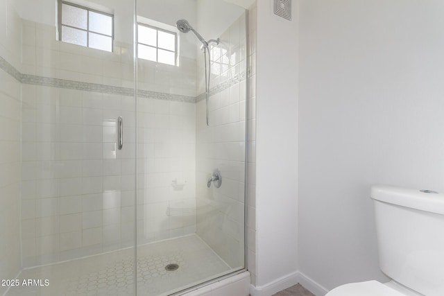 bathroom featuring walk in shower and toilet