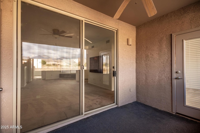 view of exterior entry featuring ceiling fan