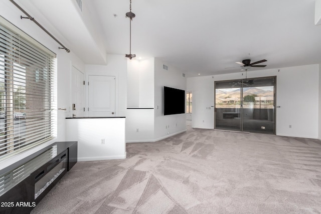 unfurnished living room featuring ceiling fan and light colored carpet