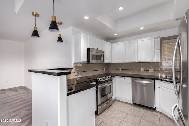 kitchen featuring stainless steel appliances, hanging light fixtures, and white cabinets