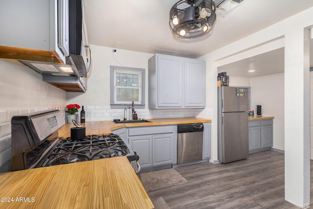 kitchen with gray cabinetry, appliances with stainless steel finishes, sink, butcher block countertops, and dark hardwood / wood-style flooring