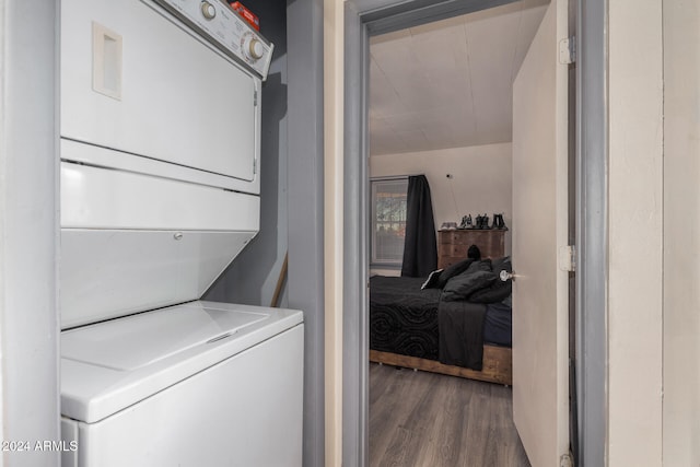 laundry room with hardwood / wood-style floors and stacked washer / dryer