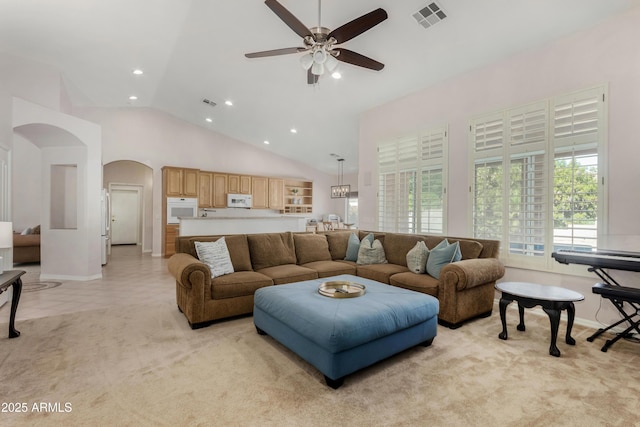 living area featuring arched walkways, recessed lighting, visible vents, light carpet, and high vaulted ceiling