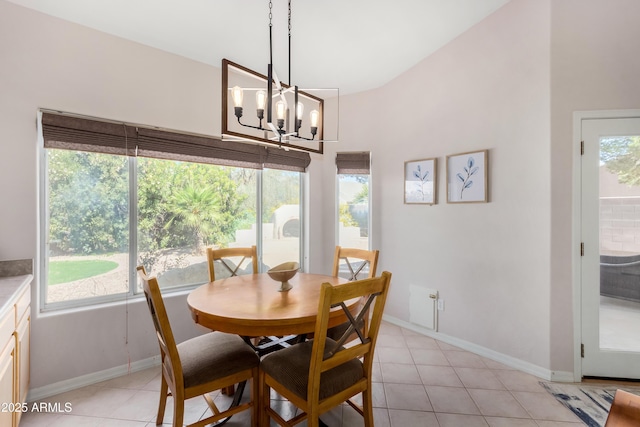 dining space featuring a chandelier, light tile patterned floors, and baseboards