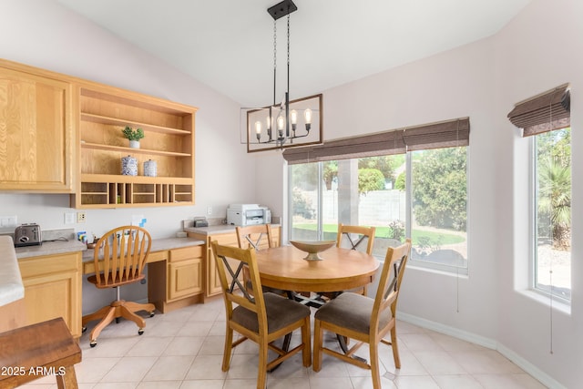 dining area featuring light tile patterned floors, baseboards, built in study area, lofted ceiling, and a chandelier