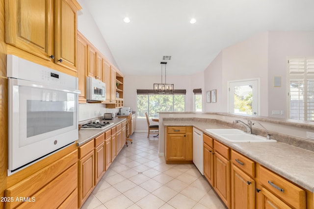 kitchen with lofted ceiling, white appliances, a sink, light countertops, and hanging light fixtures