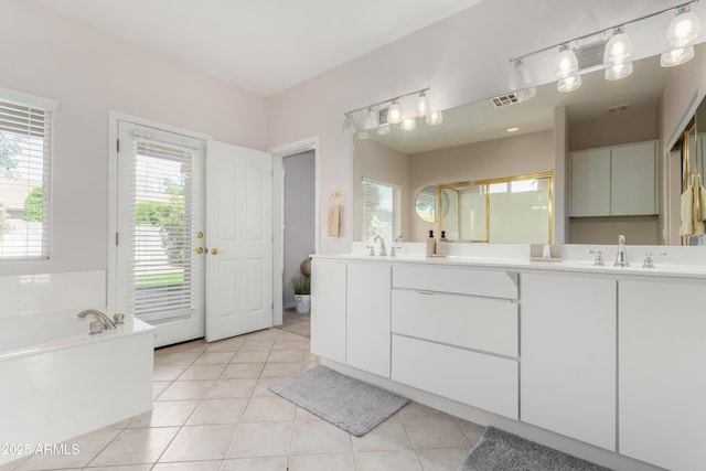 full bathroom with double vanity, tile patterned floors, visible vents, a sink, and a bath