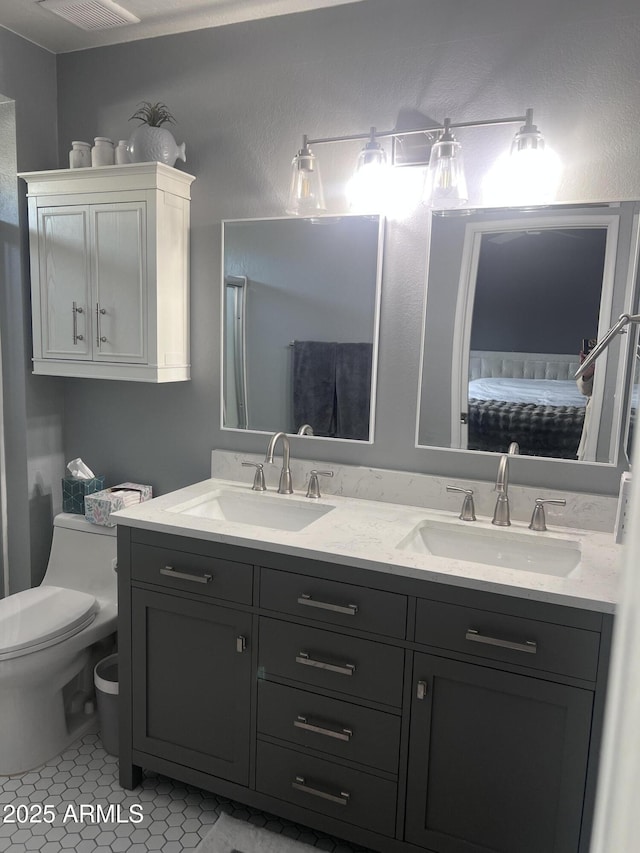 bathroom with toilet, tile patterned floors, and vanity