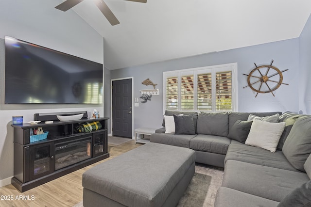 living room featuring ceiling fan, light hardwood / wood-style floors, and lofted ceiling