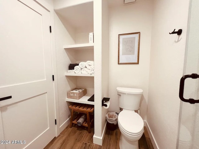 bathroom with hardwood / wood-style floors and toilet