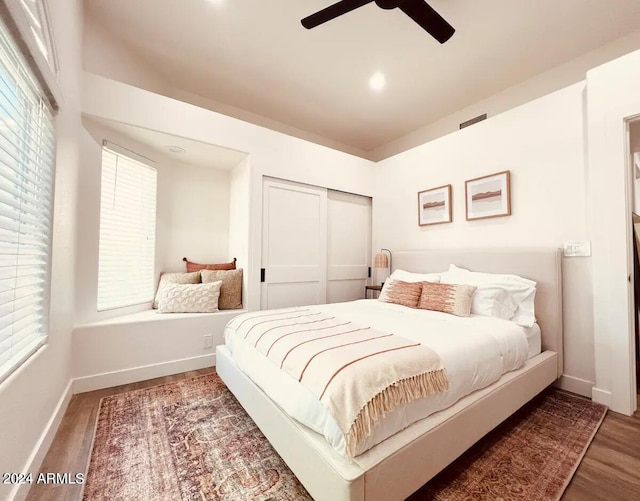 bedroom with wood-type flooring, ceiling fan, and a closet