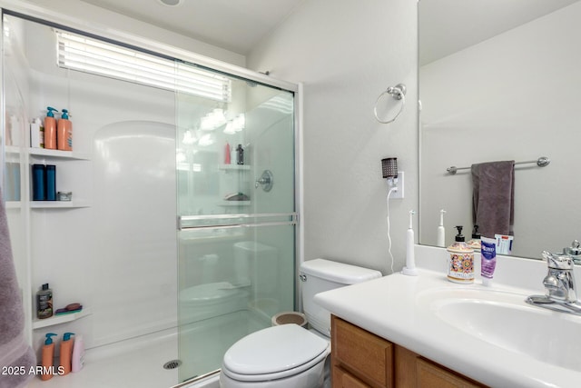 bathroom featuring vanity, a shower stall, and toilet