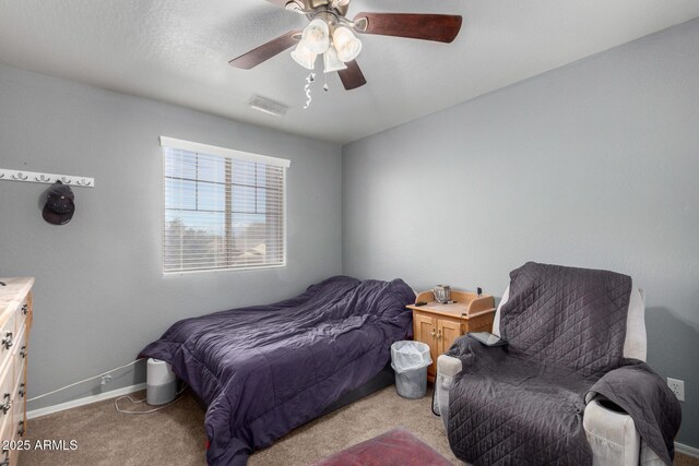 bedroom featuring visible vents, light colored carpet, a ceiling fan, and baseboards