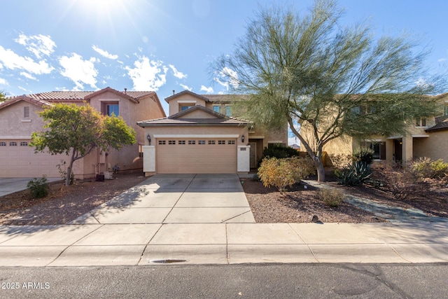 traditional-style house featuring a tile roof, concrete driveway, a garage, and stucco siding