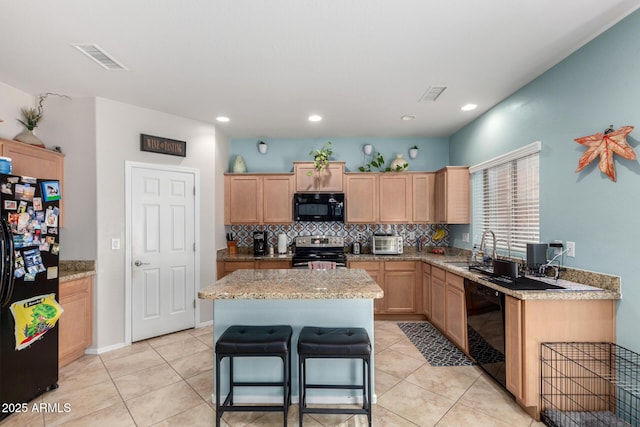 kitchen with visible vents, black appliances, light brown cabinets, light tile patterned floors, and decorative backsplash