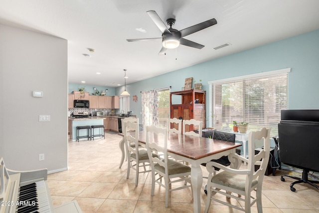 dining space featuring light tile patterned floors, visible vents, and a ceiling fan