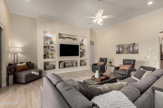 living room featuring light wood-style floors, ceiling fan, ornamental molding, and arched walkways