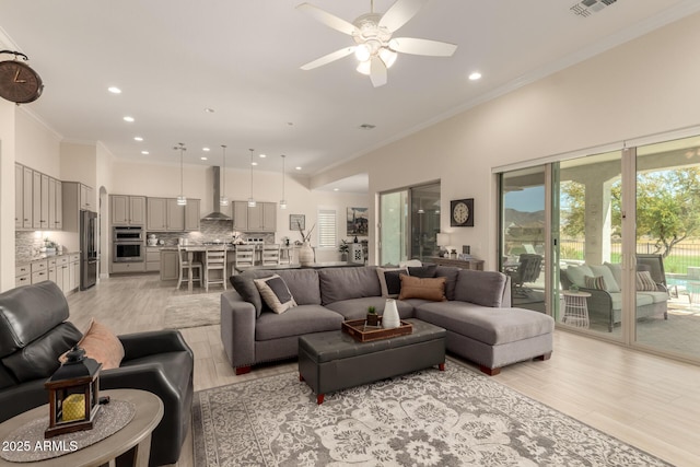 living area featuring visible vents, ceiling fan, crown molding, light wood-type flooring, and recessed lighting