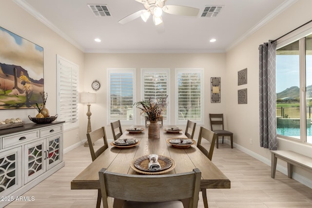 dining area with a wealth of natural light, visible vents, and crown molding