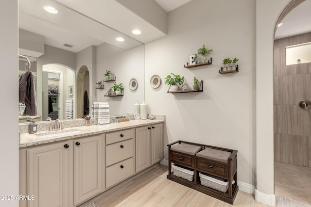 bathroom featuring double vanity, recessed lighting, visible vents, a sink, and walk in shower