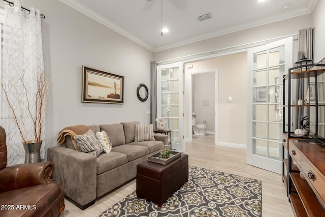 living room with a ceiling fan, baseboards, french doors, ornamental molding, and light wood-type flooring