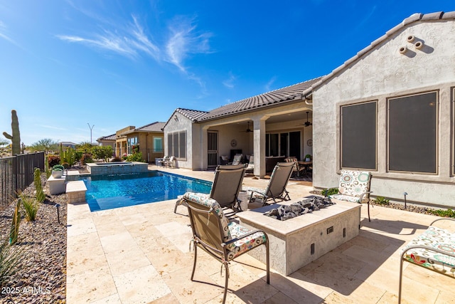 view of swimming pool with an outdoor fire pit, a patio, ceiling fan, a fenced backyard, and a pool with connected hot tub