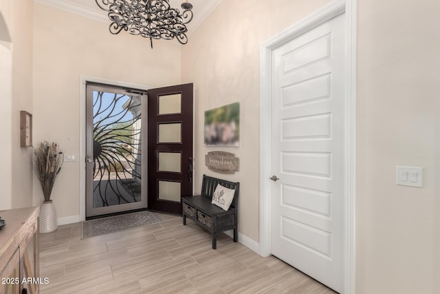 entrance foyer with baseboards, light wood finished floors, and crown molding