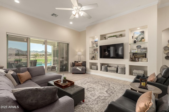 living room with ceiling fan, built in shelves, wood finished floors, visible vents, and ornamental molding