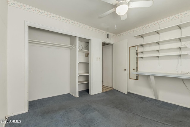 unfurnished bedroom featuring visible vents, dark colored carpet, and ceiling fan