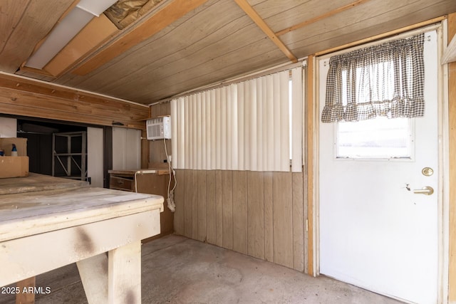 misc room with wooden ceiling, unfinished concrete flooring, and wood walls