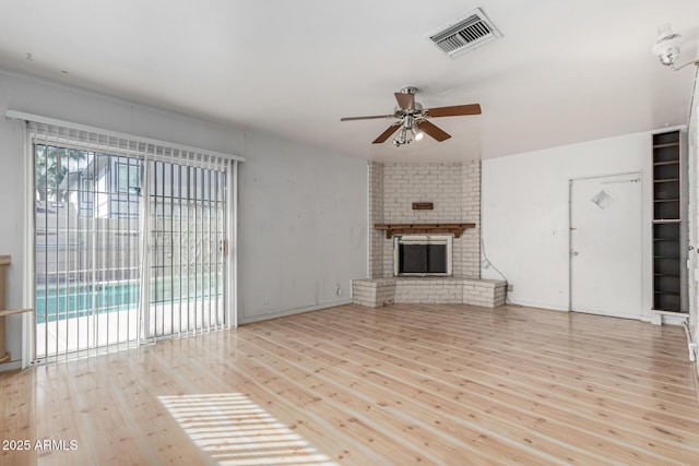 unfurnished living room with a wealth of natural light, visible vents, hardwood / wood-style floors, and a fireplace